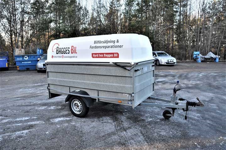 Täckt släpvagn kopplad till en personbil